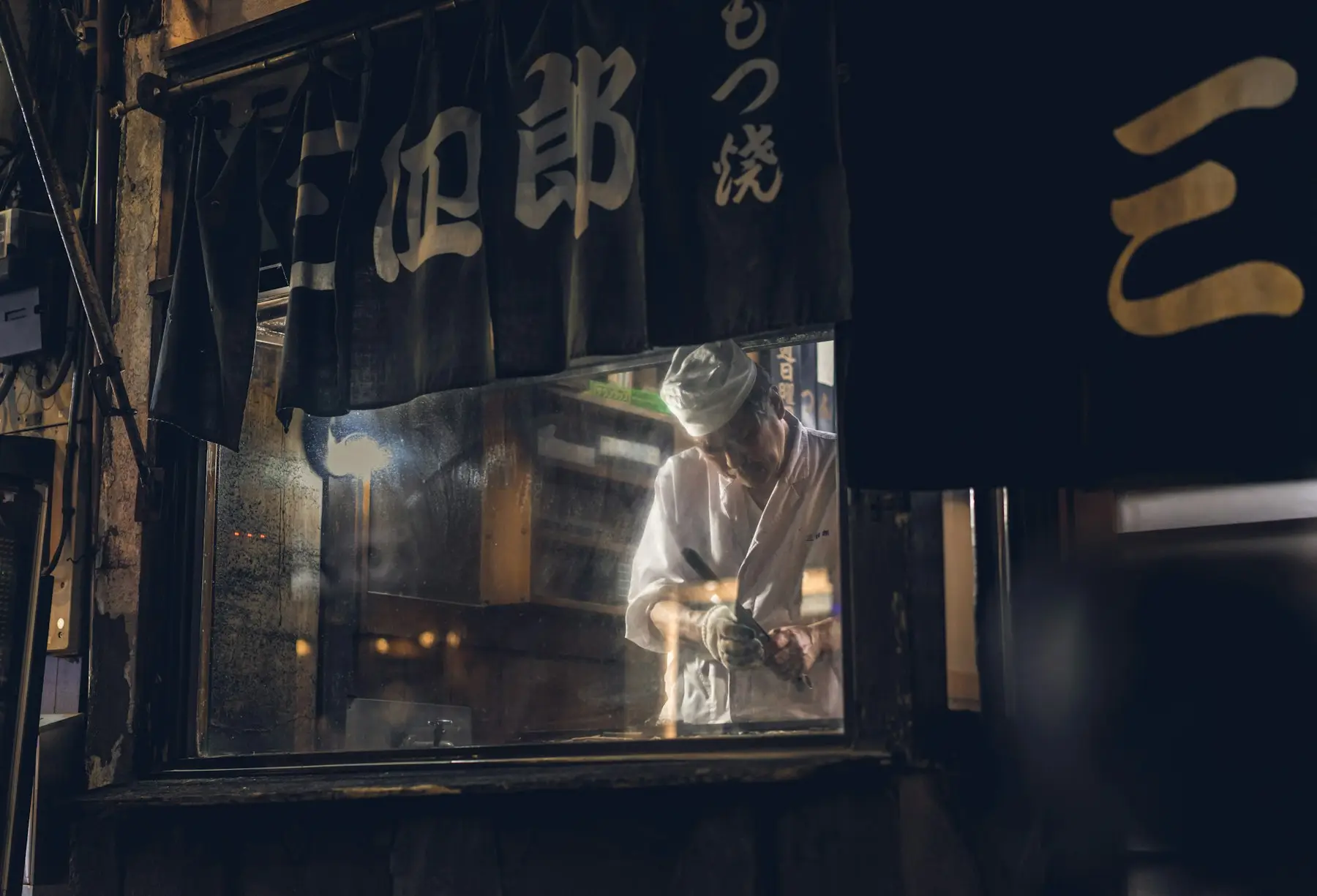 焼き場で串を返す店主の手元